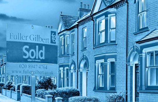 Image of a Fuller Gilbert Estate Agents 'Sold' board outside terraced houses